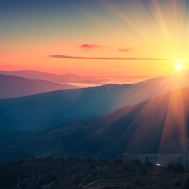 Panoramic view of  colorful sunrise in mountains. Filtered image:cross processed vintage effect.